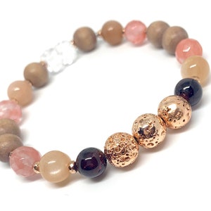May include: A bracelet featuring brown wooden beads, pink and beige gemstone beads, and gold lava rock beads.