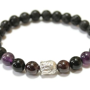 Puede incluir: Un brazalete de cuentas de lava negra, amatista y granate con un dije de Buda plateado.