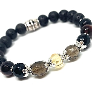 Könnte beinhalten: Ein Perlenarmband mit schwarzen Lavasteinperlen, facettiertem schwarzem Onyx, Rauchquarz und Citrinperlen. Das Armband hat silberfarbene Metallakzente und einen Mix aus Texturen und Farben.