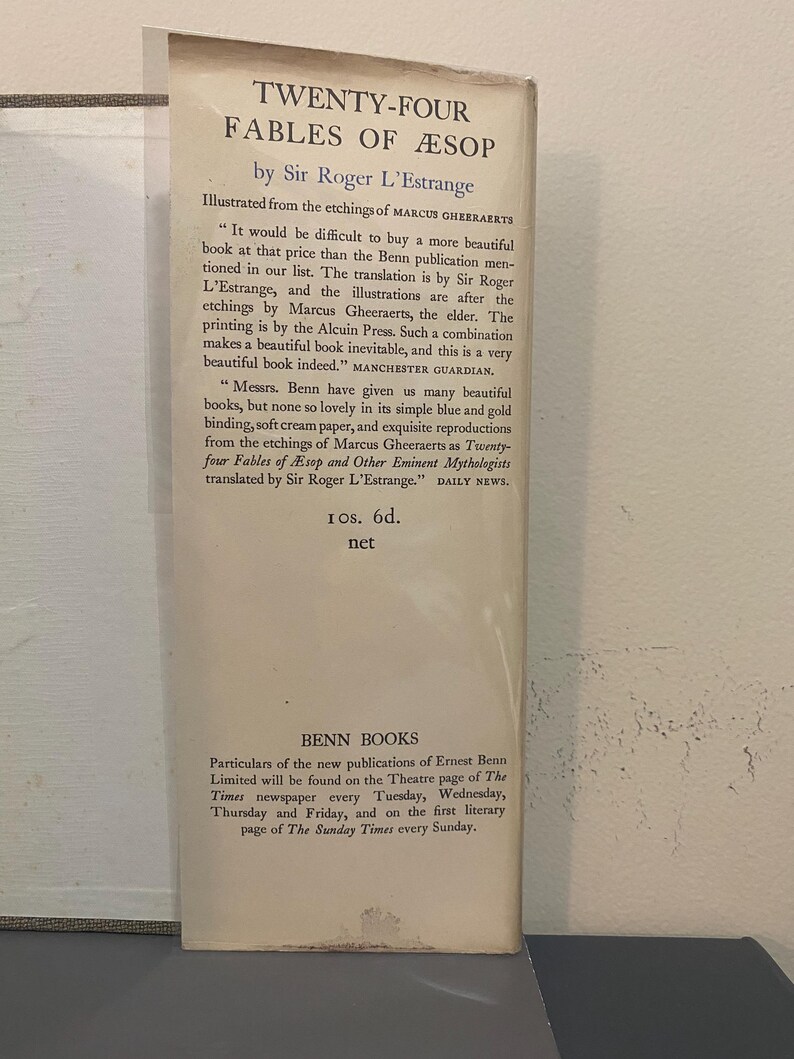 May include: A vintage book cover for "Twenty-Four Fables of &AElig;sop" by Sir Roger L'Estrange. The cover features text in black font, with quotes from the Manchester Guardian and Daily News. The book is published by Benn Books.