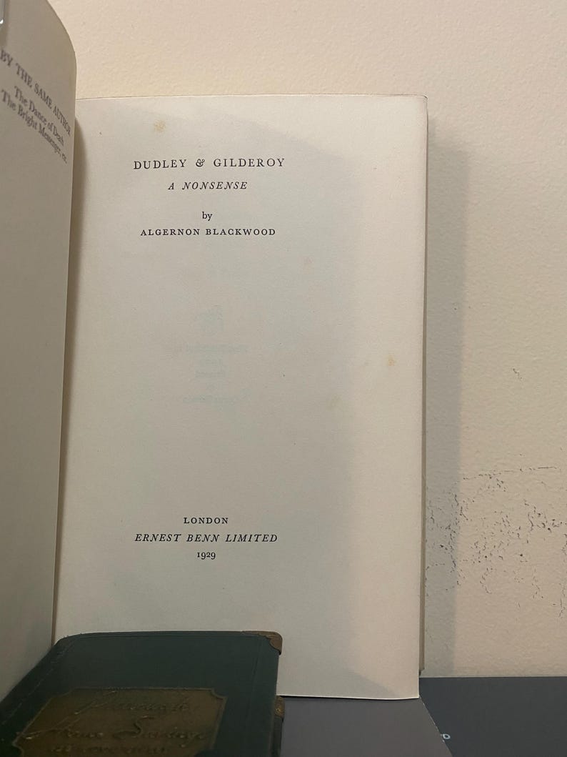 May include: Open book page with the title "DUDLEY & GILDEROY A NONSENSE" by Algernon Blackwood. Published in London by ERNEST BENN LIMITED in 1929. The book's pages are off-white, with text in black.