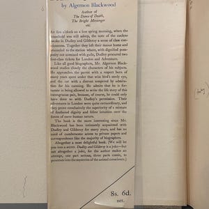May include: A vintage book page with the title "Dudley & Gilderoy" by Algernon Blackwood. The text describes the book's characters and themes, with a price of 8s. 6d. visible. The page is aged with a slight yellowing.