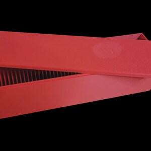 Puede incluir: Una caja rectangular roja con una tapa ligeramente abierta, que revela divisores verticales en el interior. La caja y la tapa son de un rojo mate s&oacute;lido sobre un fondo negro. La tapa tiene una hendidura circular.