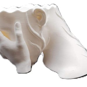 May include: A white, sculptural planter featuring a hand cradling the base of the pot. The rim of the planter has a wavy design. The planter is made of a smooth, solid material.