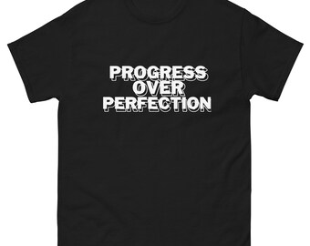 May include: Black t-shirt with white text that reads "PROGRESS OVER PERFECTION" in a bold, 3D-style font.