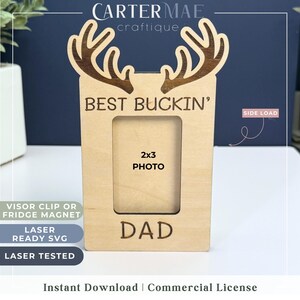 Op de afbeelding: Houten fotolijst met een hertengewei-ontwerp. De lijst zegt "Best Buckin' Dad" en heeft een fotoopening van 2x3. Het is lasergesneden en klaar om in elkaar te zetten.