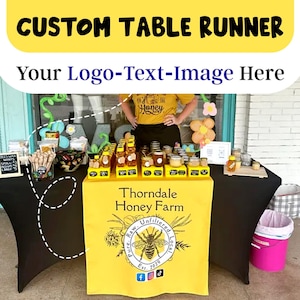Puede incluir: Un mantel de mesa amarillo con un logotipo en blanco y negro para Thorndale Honey Farm. El logotipo presenta una abeja, las palabras "Unfiltered", "Pure. Raw", "Local" y "Est. 2020". El mantel de mesa se muestra en una mesa con frascos de miel y otros productos de miel.