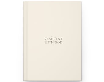 May include: A cream-colored journal with the text "RESILIENT WITH GOD" printed in black.