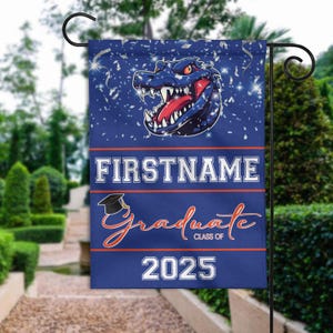 May include: Blue and orange graduation yard flag with a cartoon alligator head, confetti, and the text "FIRSTNAME Graduate Class of 2025".