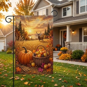 May include: A rectangular garden flag featuring a sunset landscape with a deer standing in a field, a large orange pumpkin, and a woven basket filled with apples. The scene includes autumn foliage, wheat stalks, and pine trees in warm colors.
