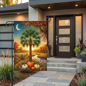 May include: A rectangular garden flag featuring a central palm tree, orange autumn foliage, a crescent moon, and a landscape with a winding stream. The foreground displays orange and white pumpkins, sunflowers, and a small American flag on a pole.
