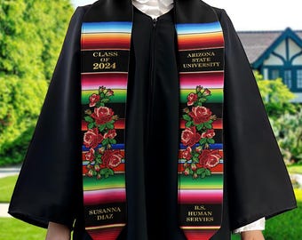 May include: A black graduation stole with colorful stripes and red roses. The stole has the text "Class of 2024", "Susanna Diaz", "Arizona State University", and "B.S. Human Services" embroidered in gold.
