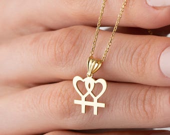 May include: A gold necklace with a pendant featuring two intertwined hearts and a cross. The pendant is a symbol of love and faith.