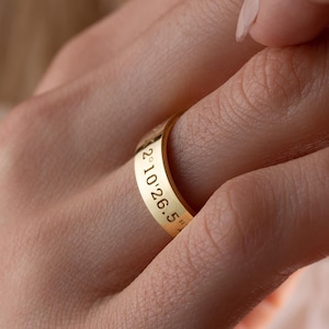 May include: A gold band ring with the inscription "2.10.26.5" engraved on the side.