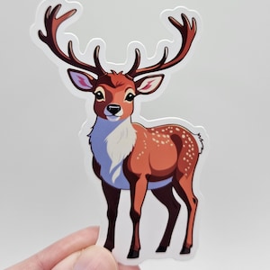 Puede incluir: Una pegatina con un ciervo de dibujos animados con grandes astas. El ciervo tiene un cuerpo marrón con manchas blancas y un pecho blanco. Las astas son de un marrón más oscuro y el fondo es blanco.
