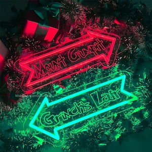 May include: Two neon signs shaped like arrows, one red and one green. The red sign says "Mount Crumpit" and the green sign says "Grinch's Lair".