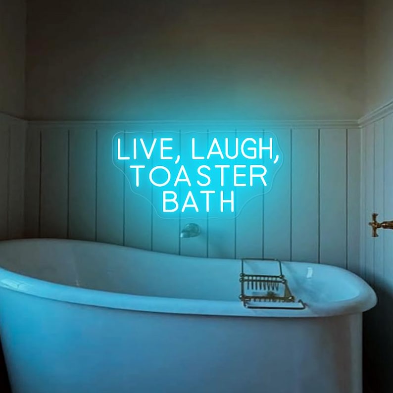 Puede incluir: Una ba&ntilde;era blanca con un letrero de ne&oacute;n azul encima que dice "Live, Laugh, Toaster Bath".