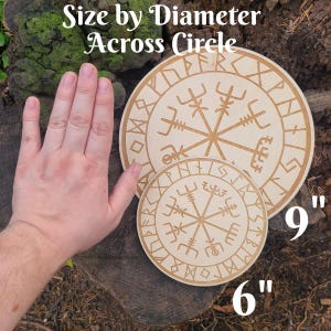 Peut inclure: Deux dessous de verre circulaires en bois avec un motif de boussole viking sculpt&eacute;. Le plus grand mesure 22,86 cm de diam&egrave;tre, le plus petit 15,24 cm. Le texte "Size by Diameter Across Circle" est en haut.