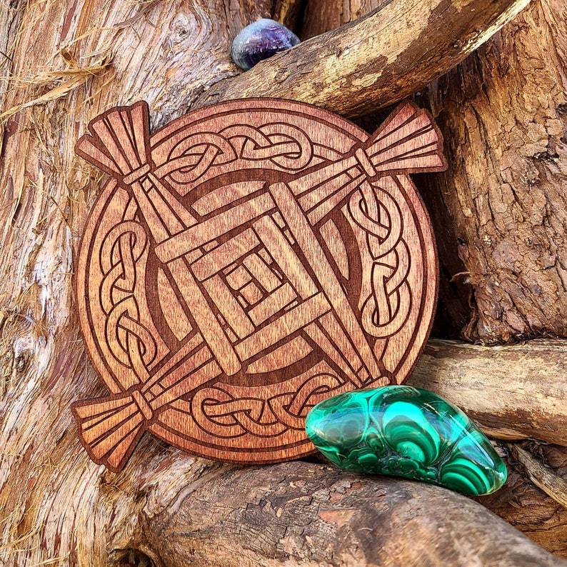 May include: A wooden Celtic knot design with a brown finish. The knot is in the shape of a cross with a square in the centre. The knot is surrounded by a circle of smaller knots. The design is on a wooden background.