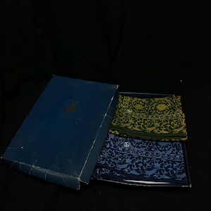 Könnte beinhalten: Eine blaue Schachtel mit zwei gemusterten Schals. Einer ist dunkelgrün mit goldenen Akzenten, der andere marineblau mit hellblauen Akzenten. Die Schals haben ein verziertes Blumen- und Vogeldesign.