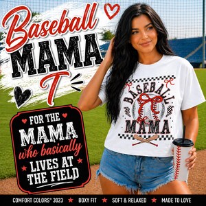 Może przedstawiać: Biała koszulka z napisem "Baseball Mama" i grafiką baseballową. Koszulka zawiera również napis "For the Mama who basically lives at the field". Koszulka jest połączona z dżinsowymi szortami.