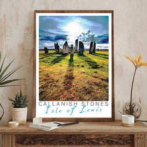 Puede incluir: Una impresión enmarcada de las piedras de Callanish en la isla de Lewis. La impresión presenta una fotografía del antiguo círculo de piedras con un cielo azul brillante y nubes blancas. El texto "Callanish Stones Isle of Lewis" está impreso en azul en la parte inferior de la impresión.