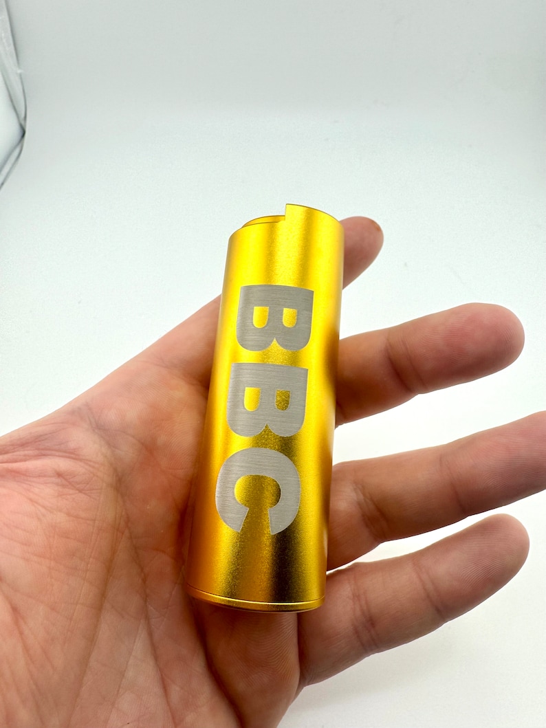May include: A gold-coloured metal tube with the word "BBC" engraved in white lettering.