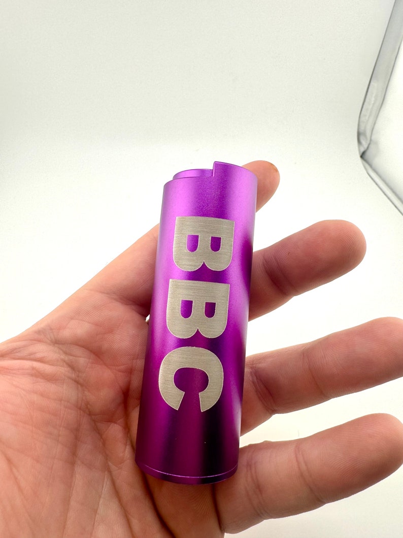 May include: A purple metal lighter with the word "BBC" engraved on the side.