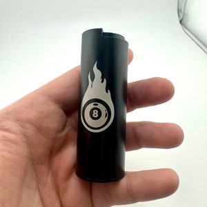 May include: Black metal lighter with a silver 8-ball and flame design.