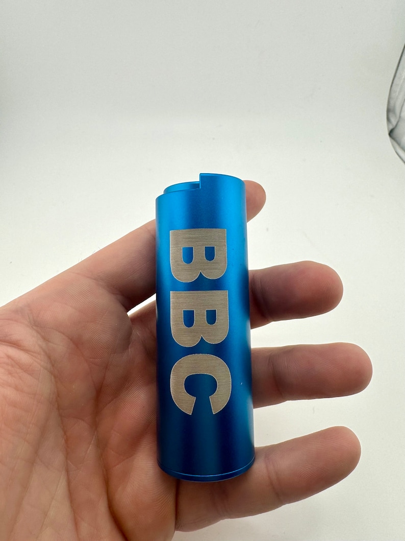 May include: A blue metal tube with the word "BBC" engraved in silver lettering.