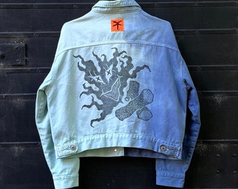 two-toned tiedye denim jacket with bright orange heart shaped patchwork details and linocut blockprinting graphics on the back