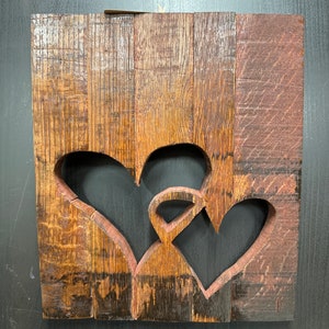 Two Hearts Barrel Stave wall mounted art hanging. Handmade with oak bourbon barrel staves and stained with 2 hearts connected to each other.