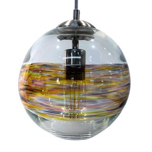 Puede incluir: Una lámpara colgante de vidrio transparente con acabado plateado. El vidrio tiene un patrón de remolino de amarillo, naranja, rosa y morado.