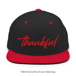 May include: Black and red baseball cap with the word "thankful" embroidered in red on the front.