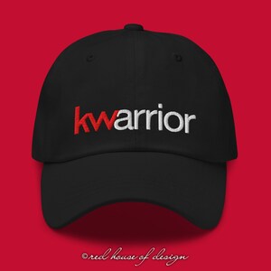 May include: Black baseball cap with the word "kwarrior" embroidered in red and white letters.