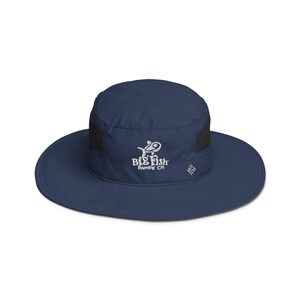 May include: A navy blue sun hat with a black mesh panel and a white embroidered logo that says "Big Fish Brewing Co."