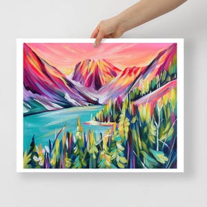 Può includere: Un colorato dipinto di paesaggio con una catena montuosa, un lago e alberi. L'opera d'arte utilizza tonalità vivaci di rosa, arancione, blu, verde e viola. Il dipinto è tenuto da una mano.