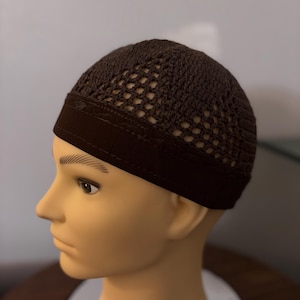 May include: A brown crocheted skullcap with a black elastic band. The skullcap has a mesh design.