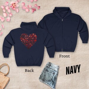 May include: A navy blue zippered hoodie with a red heart design on the back. The heart is made up of many smaller hearts. The hoodie is shown on a model wearing jeans.