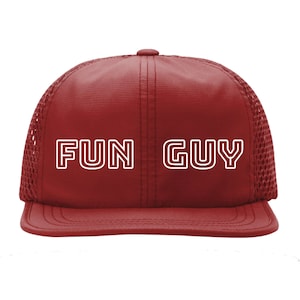 May include: A red mesh trucker hat with a white outline of the words "FUN GUY" on the front.