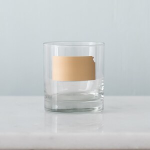 May include: A clear glass tumbler with a gold outline of the state of Kansas.