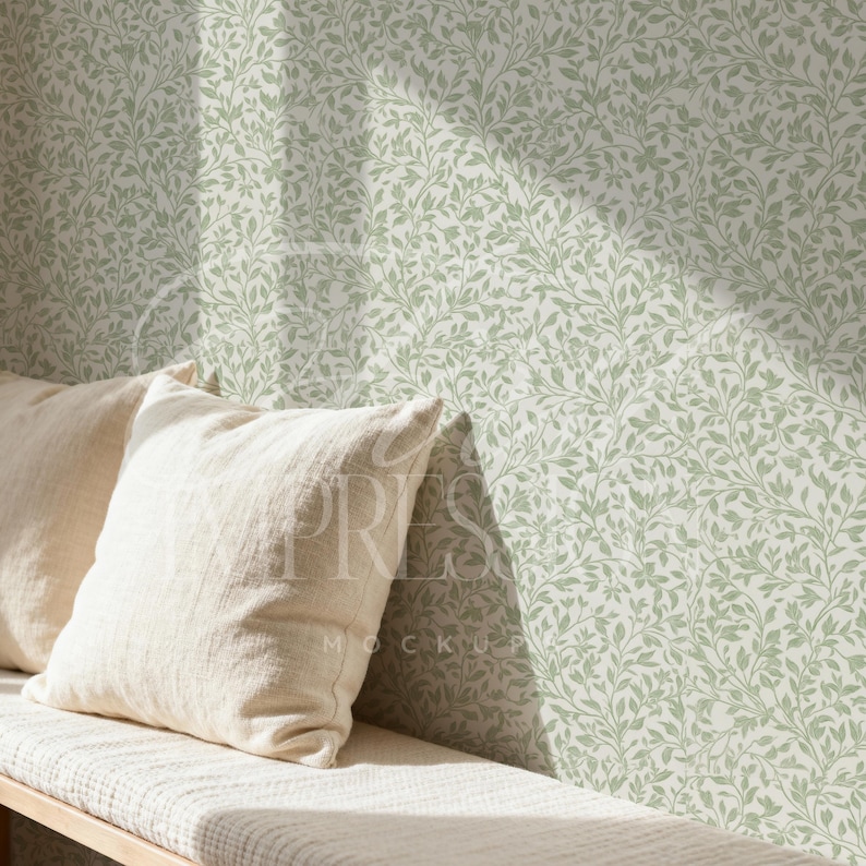 May include: A light-colored bench with two cream-colored pillows. The wall behind the bench is covered in a green and white floral wallpaper pattern. The wallpaper has a repeating design of leaves and vines.