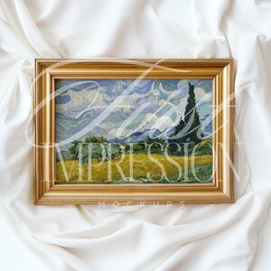 Puede incluir: Una pintura enmarcada de un paisaje con un campo de trigo amarillo y un cielo azul con nubes blancas. La pintura est&aacute; en un marco dorado y est&aacute; sobre un fondo de tela blanca.