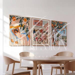 May include: Three framed art prints with a white background. The left print features a woman laying down with orange trees in the background. The middle print features a cafe with the text "Bosco Cafe" and a bicycle in the foreground. The right print features a street scene with orange trees and a white building.