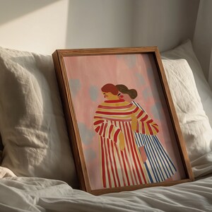 May include: A framed illustration of two people standing side-by-side. The person on the left is wearing a red and white striped dress. The person on the right is wearing a blue and white striped dress. The background is a light pink color with white dots.