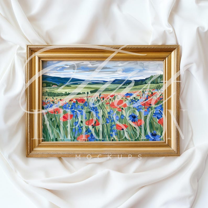 Puede incluir: Una pintura enmarcada que representa un campo de flores azules y rojas con un paisaje distante en el fondo. El marco es dorado y tiene un dise&ntilde;o simple.