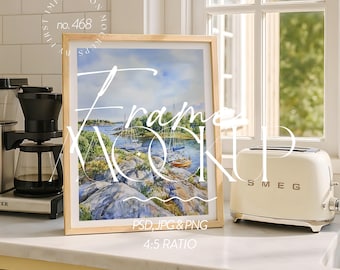 May include: A framed watercolor print of sailboats on a lake, with a light wood frame. A cream-colored toaster is to the right of the frame. The text "Frame Mockup" is overlaid on the image.
