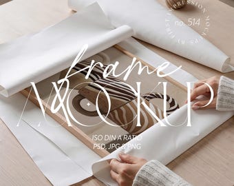 Puede incluir: Una maqueta de marco de madera con una impresión artística abstracta neutra. El arte presenta formas geométricas marrones y beige. El marco se está envolviendo en papel blanco. El texto "frame MOCKUP" está superpuesto en la imagen.