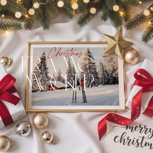 Könnte beinhalten: Ein goldgerahmter Winterlandschaftsdruck mit roten Skiern, umgeben von Weihnachtsschmuck, Geschenken mit roten Schleifen und einem goldenen Stern. Das Bild ist vor einem weißen Hintergrund mit Tannenzweigen und Lichterketten angeordnet.