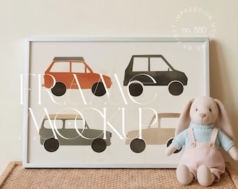 May include: A framed print featuring four stylized car illustrations in shades of orange, black, gray, and beige. The print is in a white frame and is displayed with a stuffed bunny on a woven basket.